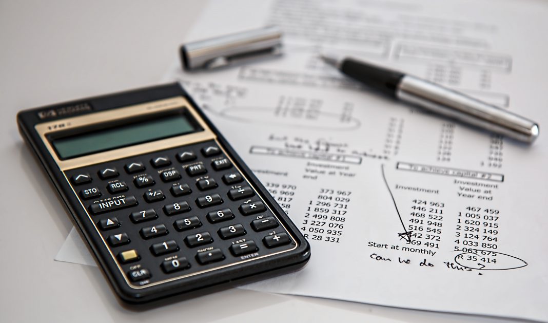 Black Calculator Near Ballpoint Pen on White Printed Paper With Financial Figures