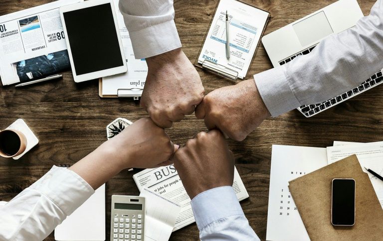 Colleagues making a fist bump at their office.